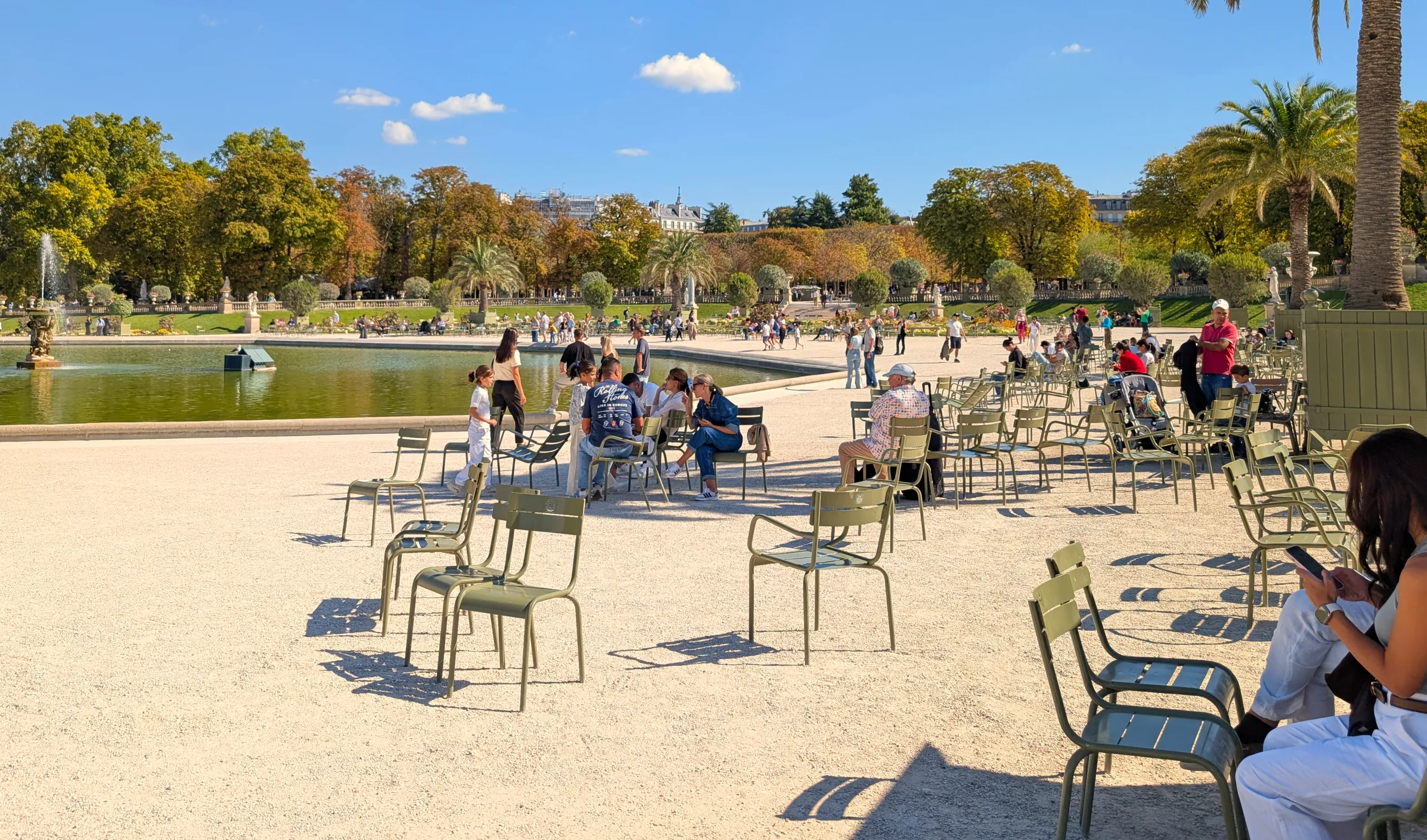 Num jardim público de estilo francês, várias cadeiras soltas são colocadas pelos habitantes de Paris na maneira que mais os convém, organizam-se em grupos ou sentam-se sós.